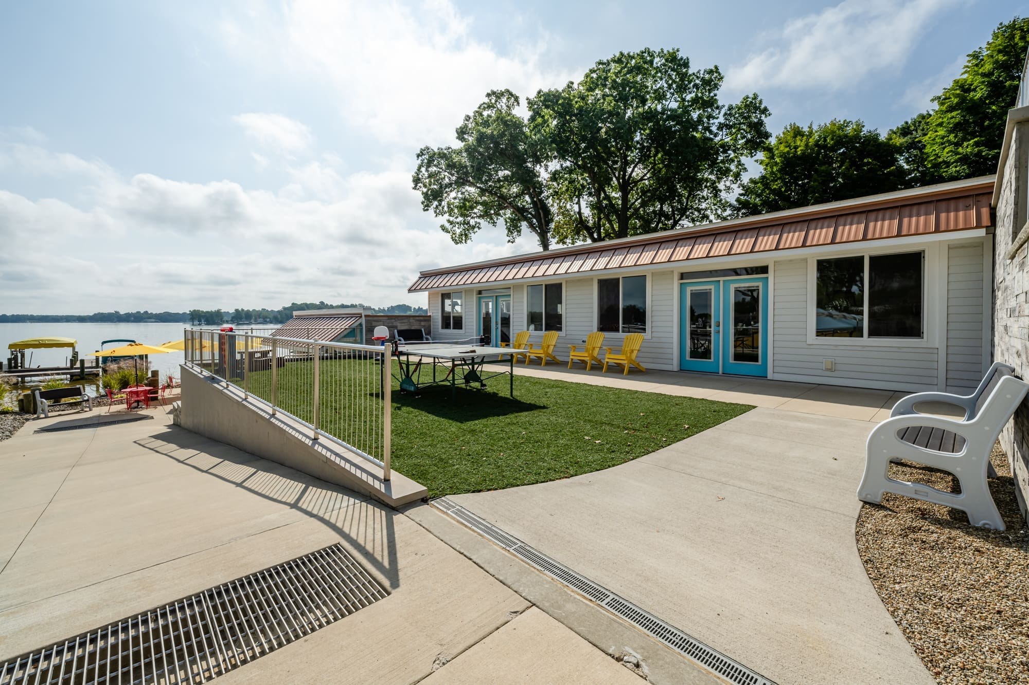 Grass area with ping pong table and yellow chairs outside the cafe