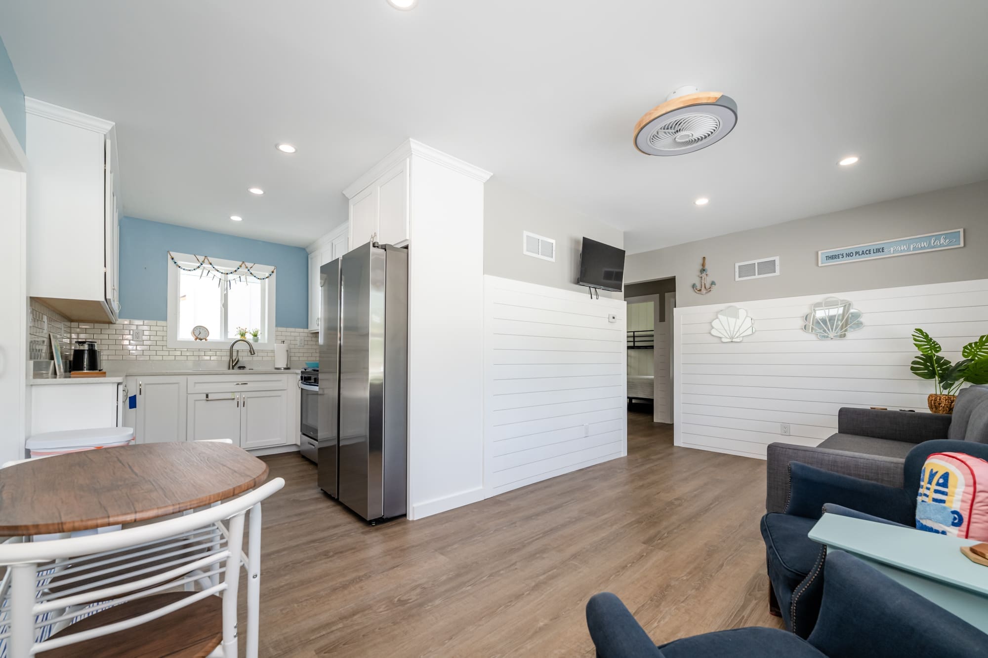 Kitchen area with white cabinetry, stainless steel appliances, and a small round dining table